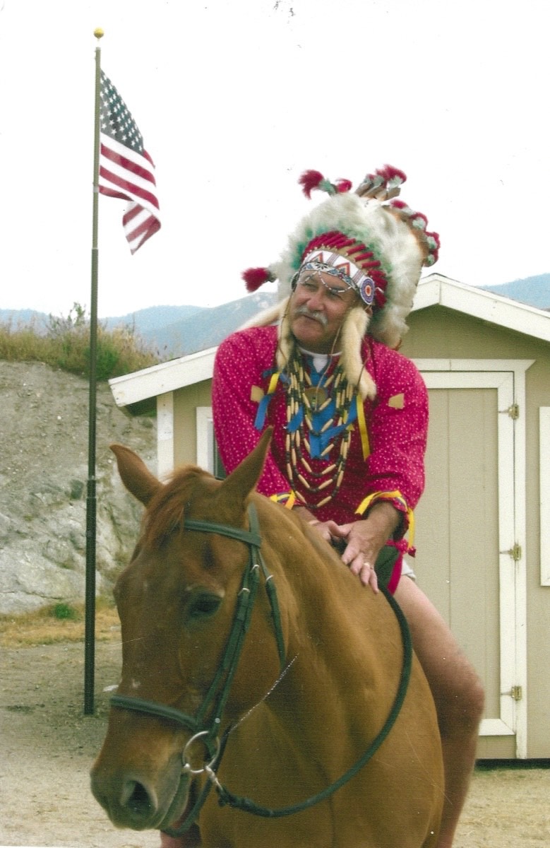 Rich Bison on horseback in Native American regalia with an American flag